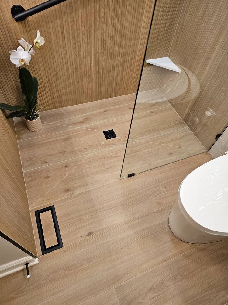 Finished shower floor with black square drain — bathroom remodel Barrington