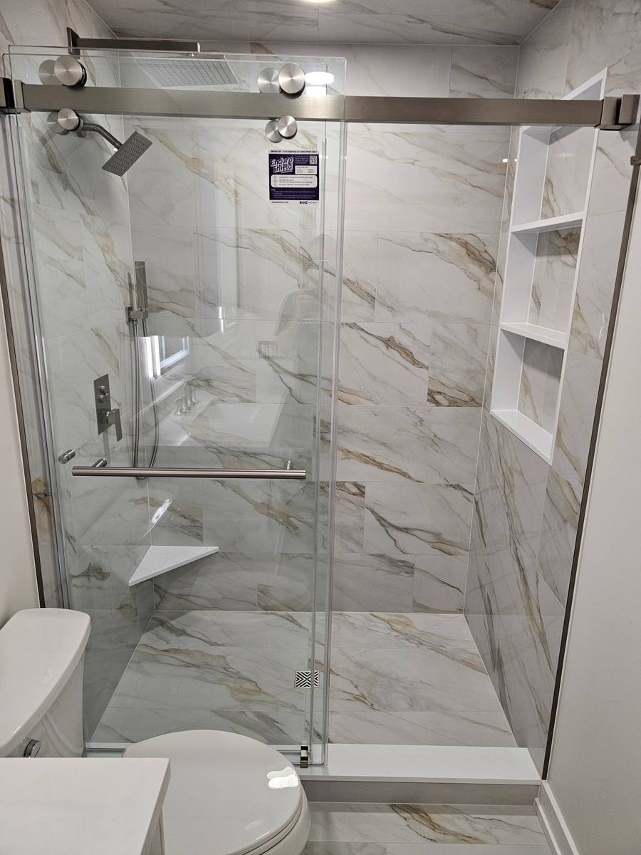 Bathroom remodel Kildeer IL — marble-look tile walk-in shower, frameless glass door, rain head, built-in niches