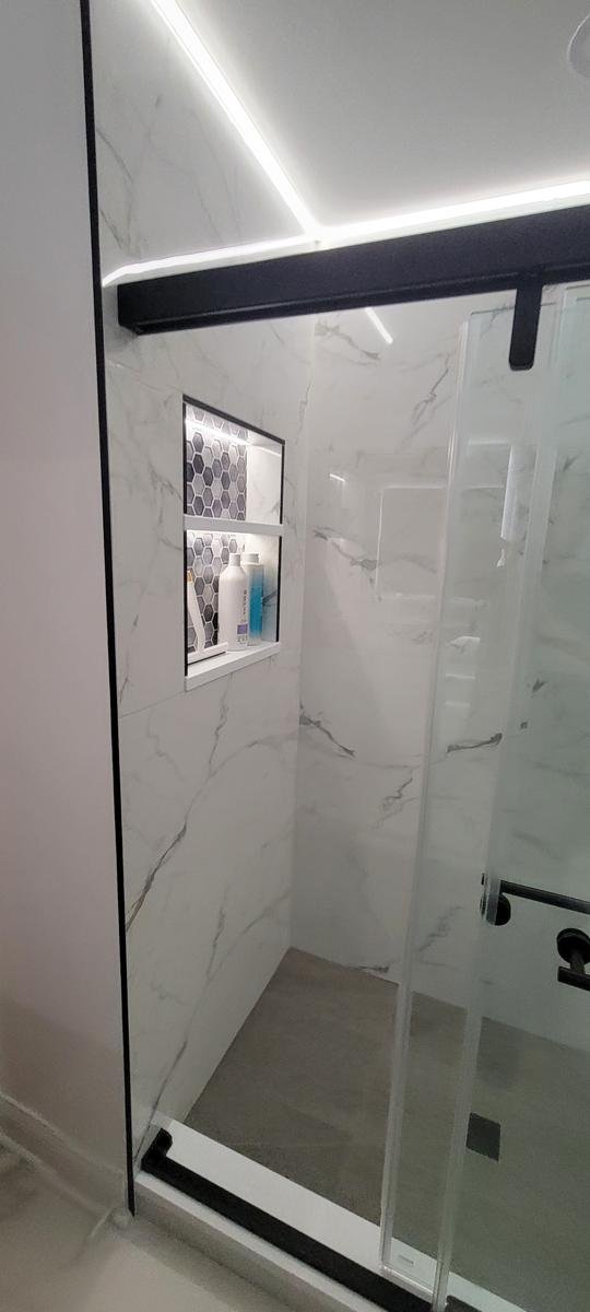 Completed walk-in shower remodel Lake Zurich IL — large-format tile and frameless glass panel